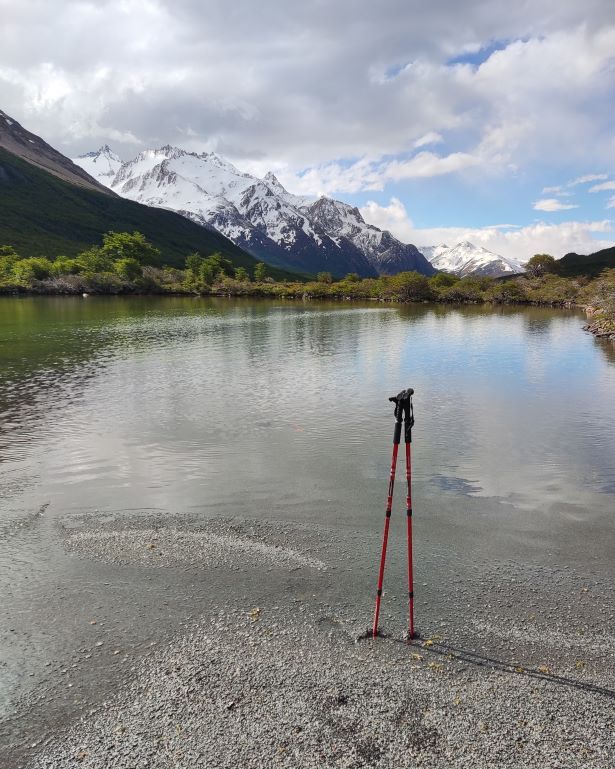 Bastones de trekking clavados a pies de la laguna madre hija