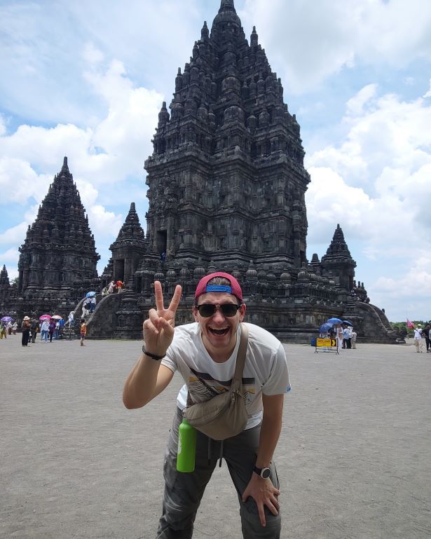 Templos de Prambanan al fondo con un chico posando delante