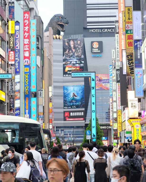 Vistas de una de las principales calles del distrito de Shinjuku, en Japón, con un Godzilla al fondo