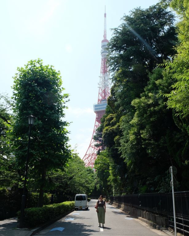 Vistas de la torre de Tokio al fondo de una calle arbolada