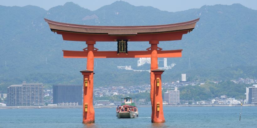 Un barco pasa por el tori de Miyajima en Japón
