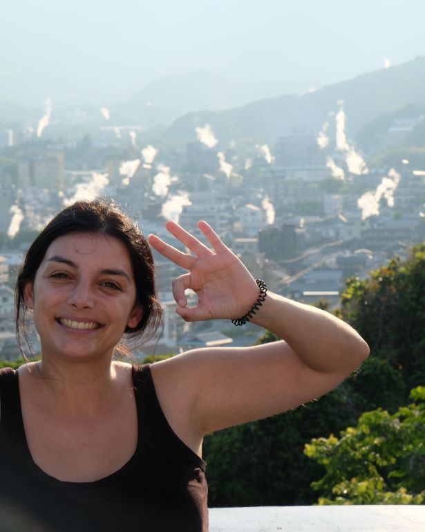 Mujer posa en el mirador de beppu donde se ven todas las fumarolas, Japón