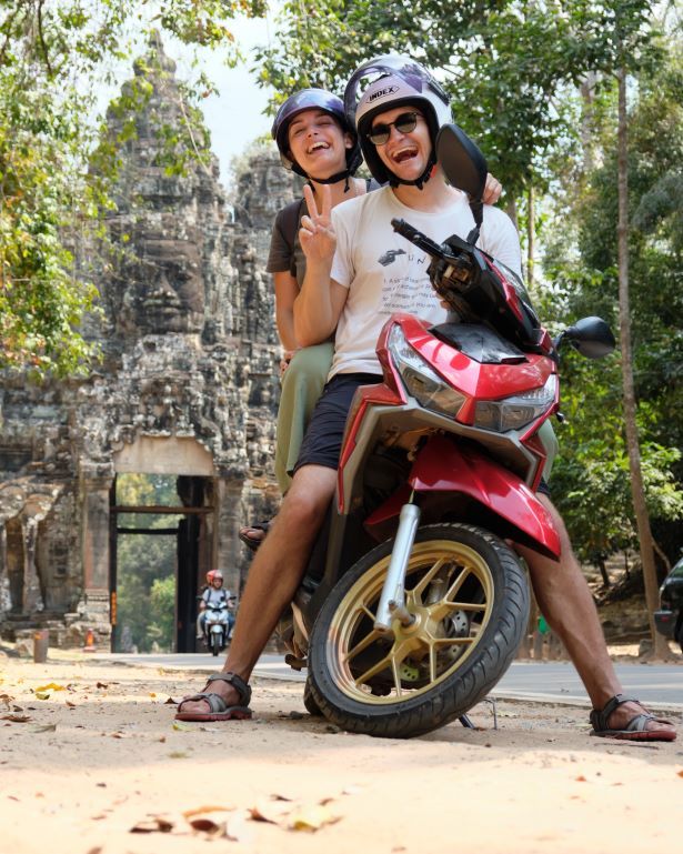 Dos personas en moto en la puerta de la victoria en Angkor, Camboya