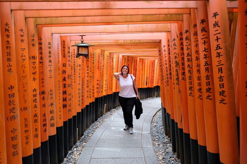 Chica camina entre los Torii de Fushimi Inari-Taisha en Kioto, Japón