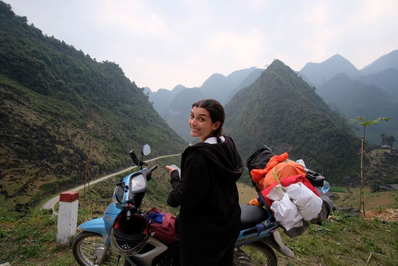 Una mujer posa en el loop de Ha Giang junto a la moto. Vietnam