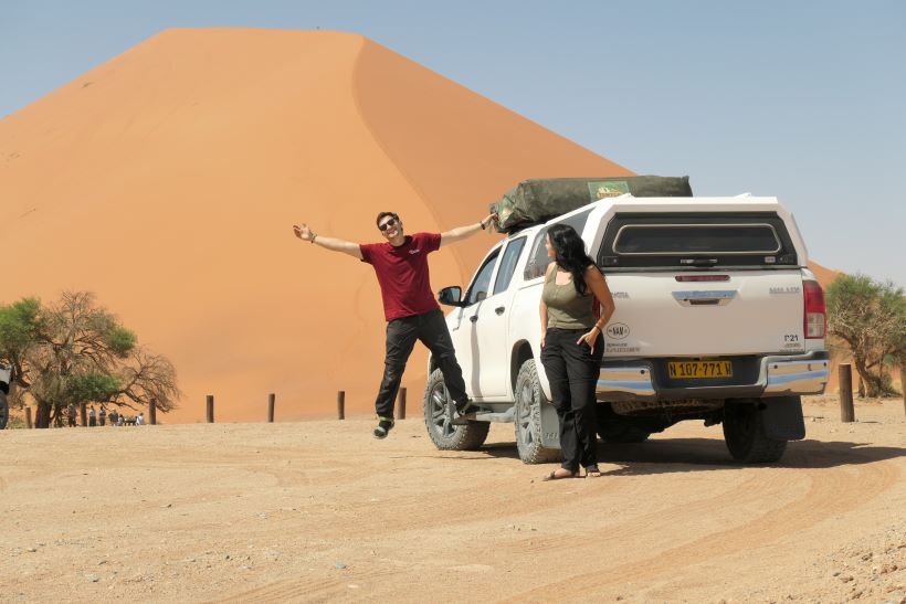 Toyota Hilux 4x4 frente a la duna 45 en sossusvlei con dos personas