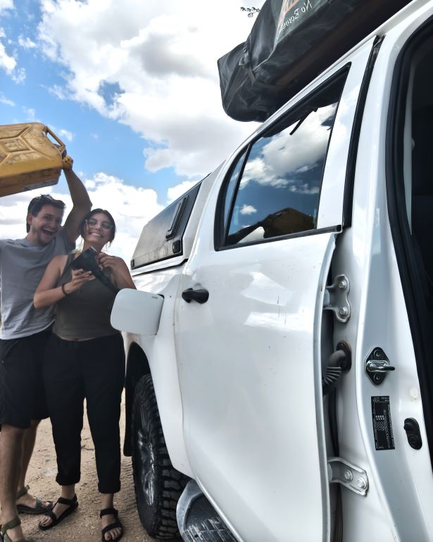 Dos personas echando combustible desde una jerry can en namibia