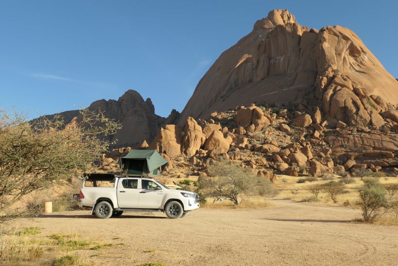 Toyota hilux 4x4 con tienda de techo acampado frente a spitzkoppe en Namibia