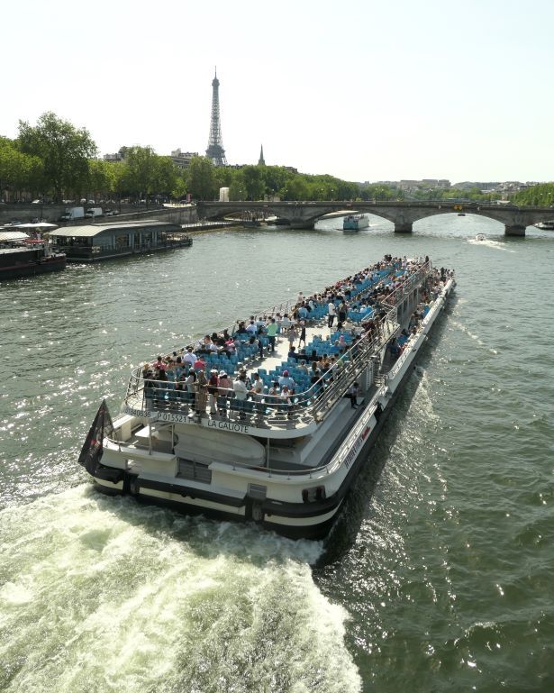 Barco de turistas en el río Sena en París, Francia, con la torre eiffel de fondo