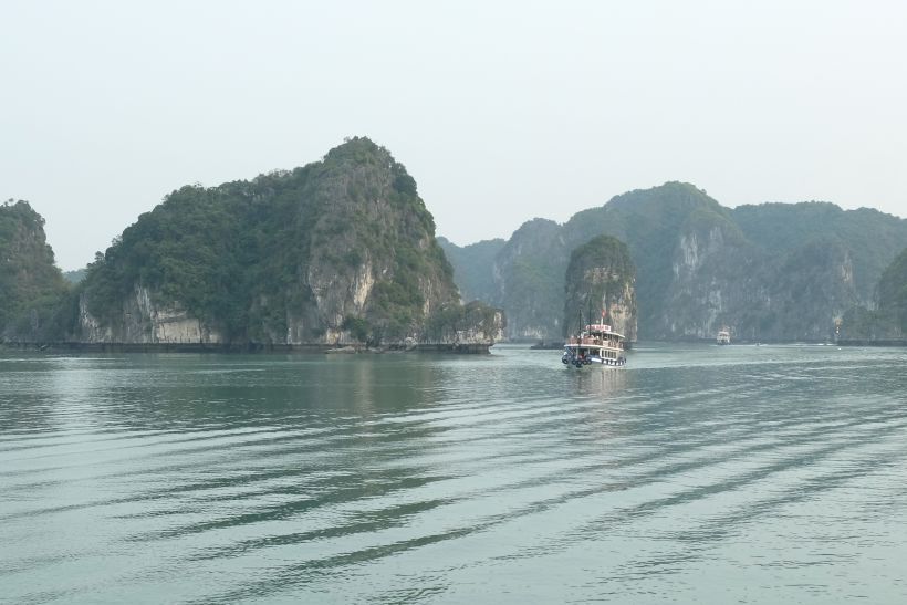 Crucero surcando la bahía de halong en vietnam entre rocas kársticas