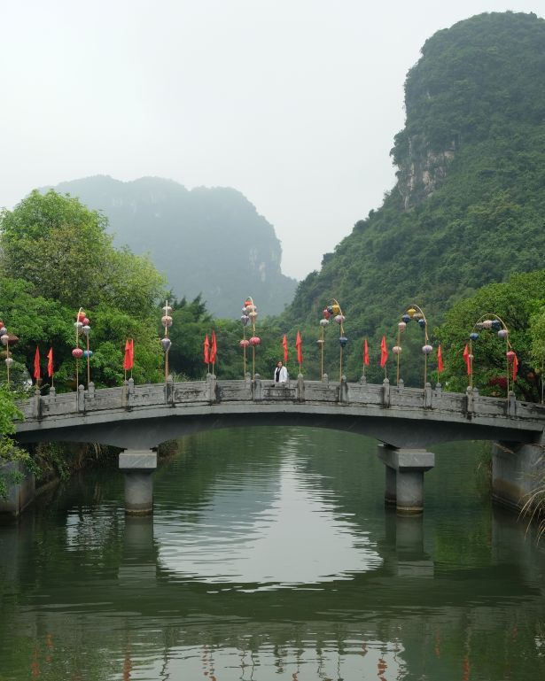 Puente sobre un río en Ninh Binh, con las montañas de fondo, Vietnam