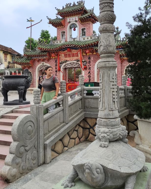 Puerta principal y entrada del salón de la asamblea de Fujian en Hoi An, Vietnam, con escaleras y una farola sujetada sobre una tortuga de piedra
